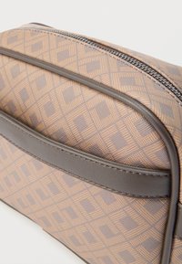 Καφέ τσάντα με γεωμετρικό σχέδιο, με γκρι δερμάτινη επένδυση και μεταλλικό φερμουάρ. Ομαλή υφή, ορθογώνιο σχήμα.