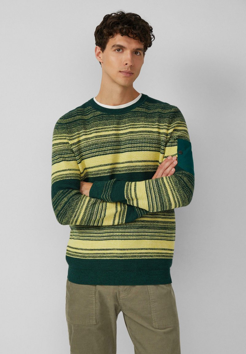 Maglione lavorato a maglia con strisce orizzontali verdi e gialle, scollatura rotonda e tasca applicata sul maniche sinistro. Tessuto testurizzato.