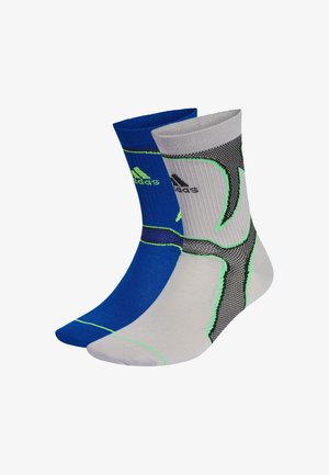 Coppia di calzini sportivi al polpaccio medio, uno blu con logo Adidas verde, l'altro grigio con motivi neri e verdi, entrambi a costine e imbottiti.