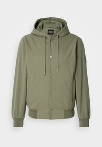 Chaqueta con capucha de color verde oliva, con botones de presión en el frontal, capucha con cordón ajustable, puños y dobladillo acanalados, bolsillos laterales y etiqueta del logo de BOSS en el interior del cuello y la manga.