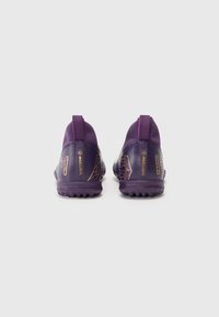Scarpe sportive viola con una tomaia testurizzata, caratteristiche gialle e bianche, colletto alto e una resistente suola in gomma con tacchetti antiscivolo.