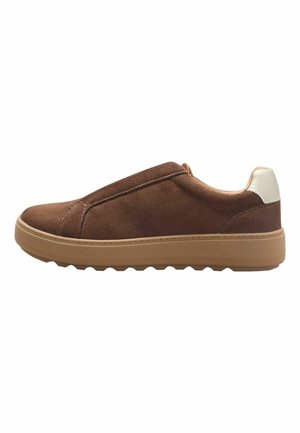 Brązowy zamszowy sneaker wsuwany z jasnobrązową gumową podeszwą i białym akcentem na pięcie, pokazany z profilu na białym tle.