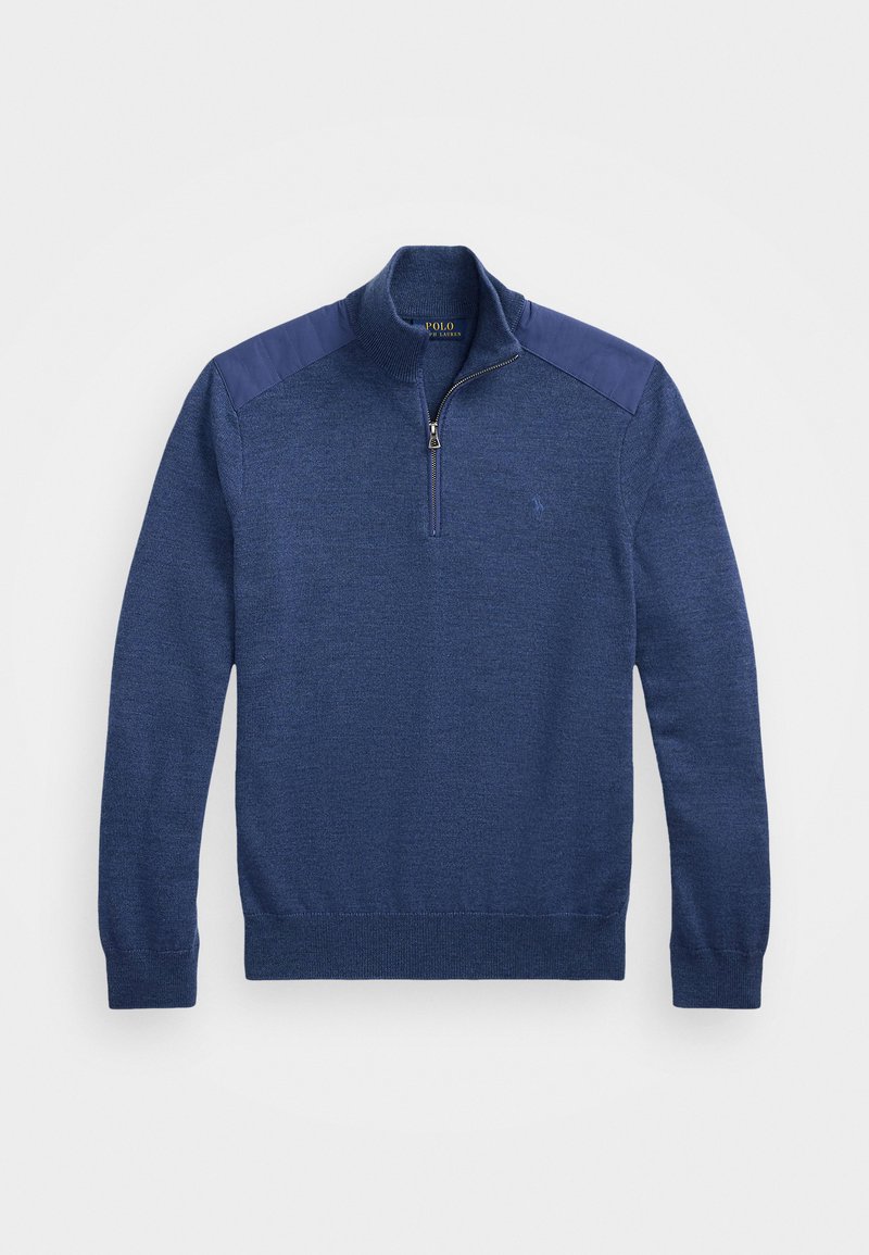 Pull de tricot bleu marine avec un col montant zippé, un corps texturé et des panneaux d'épaule lisses en contraste. Petit logo sur la poitrine.
