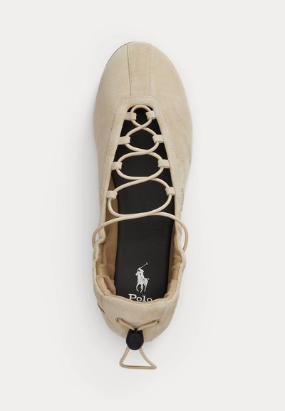 Μπεζ σουέντ μπαλαρίνα με σταυρωτά κορδόνια, μαύρο πάτο με λογότυπο Polo και ρυθμιζόμενο κουμπί στο πίσω μέρος.