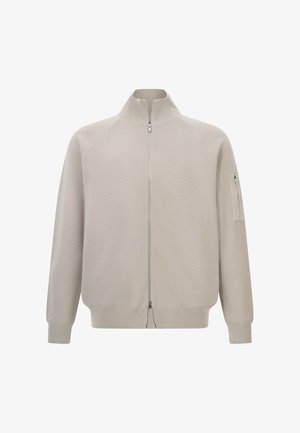 Helle beigefarbene Zip-up-Pullover mit hohem Kragen, gerippten Bündchen und Saum sowie einer Reißverschlusstasche am linken oberen Ärmel.