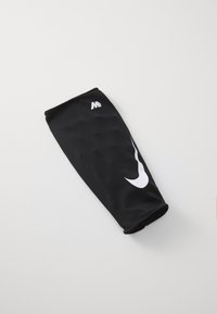 Manchette de sport noire en tissu maillé respirant, avec un logo Nike swoosh blanc et un bord lisse et sans couture.