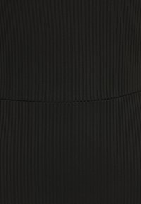 Černá jemně vroubkovaná látka s vertikálními pruhy a hladkou strukturou, která má přiléhavý střih s detailem v pase.