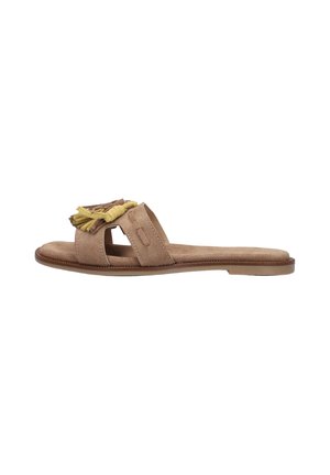 Platte beige suède slide sandaal met open teen, brede band en gele kwastdecoratie bovenop, tegen een witte achtergrond.