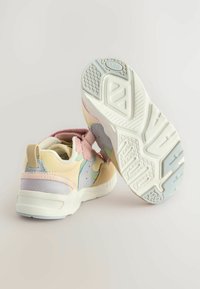 Mønstret sneakers i flere farver, fremstillet af blødt ruskind og mesh-materialer, med en velcro-rem og en struktureret gummisål med et geometrisk mønster.