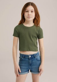 Zöld, bordázott, rövid ujjú crop top, kék farmer, magas derekú sorttal párosítva, gombos záródással és feltekert szegéllyel.