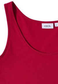 Červený top bez rukávů s kulatým výstřihem a viditelným štítkem značky "CECIL" a štítkem velikosti S uvnitř límce.