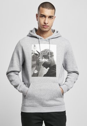 Grå hoodie laget av myk stoff med en front kangaroo-lomme. Har et stort svart-hvitt grafikk av en mann som har på seg bandana.