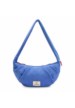 Bolso de hombro azul suave con forma de media luna, con tira ancha y pequeña etiqueta rectangular en el frente, con tiradores de cremallera naranjas en cada lado.