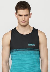 Juodas tankas su turkio spalvos dryžiais per krūtinę, su turkio spalvos logotipu. Lygus, lengvas audinys, be rankovių dizainas.