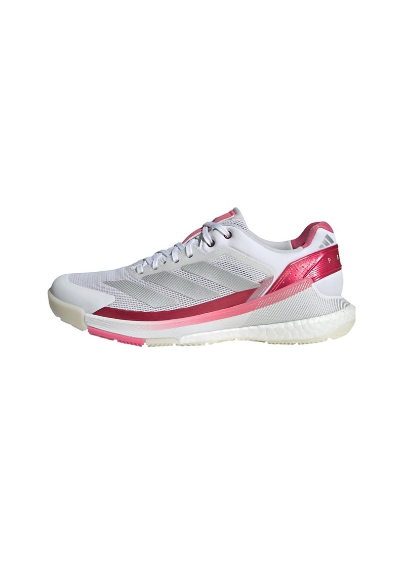 Buty sportowe w białym kolorze z różowymi akcentami. Posiadają oddychającą siateczkę na górze, teksturowane boki oraz amortyzowaną podeszwę zapewniającą wsparcie.