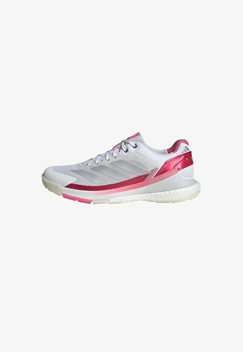 Sport shoe in white with pink accents. Features a breathable mesh upper, textured sides, and a cushioned outsole for support.