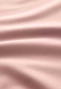 Material moale, texturat, de culoare roz pal, cu cute fine și un luciu subtil, indicând un material ușor.