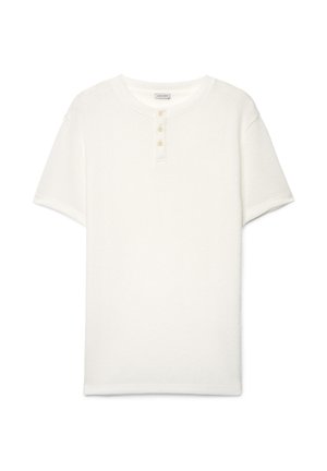 Weißes kurzärmeliges Frotteehemd mit rundem Ausschnitt und drei Knöpfen vorne, als flache Lage auf weißem Hintergrund.