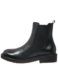 Botín Chelsea de cuero negro con paneles elásticos a los lados, puntera redondeada y suela de goma texturizada y duradera. Diseño clásico adecuado para diversas ocasiones.
