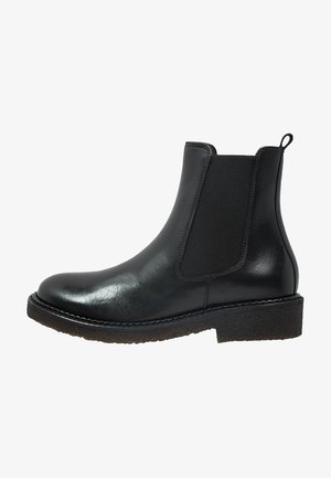 Botín Chelsea de cuero negro con paneles elásticos a los lados, puntera redondeada y suela de goma texturizada y duradera. Diseño clásico adecuado para diversas ocasiones.