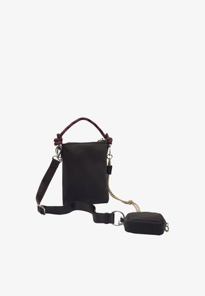 Czarna torba na ramię z regulowanym paskiem, górną rączką wykonaną z bordowego sznurka oraz małą odpinaną saszetką przymocowaną metalowym pierścieniem.