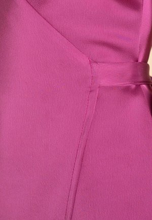 Vestido fucsia con una tela suave y texturizada, con una costura lateral y un cinturón de tela para un detalle adicional. Silueta clásica con un diseño estructurado.
