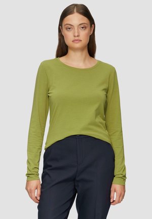Haut à manches longues vert avec un col rond, en matière douce et extensible. Assorti à un pantalon bleu marine, offrant une coupe décontractée.