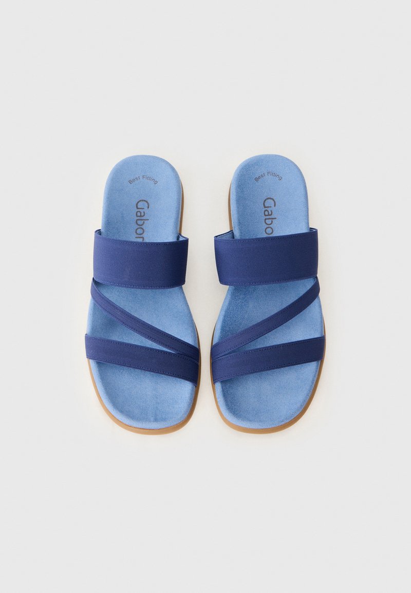 Niebieskie sandały o miękkiej, zamszowej fakturze i elastycznych paskach w ciemnoniebieskim kolorze. Posiadają profilowaną wkładkę i jasnobrązową podeszwę.