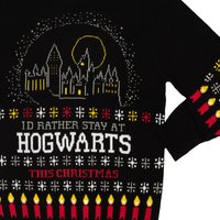 Schwarzer Strickpullover mit einem Hogwarts-Schlossdesign, bunten Kerzen und Musterakzenten sowie dem Text "ICH WÜRDE LIEBER AN WEIHNACHTEN IN HOGWARTS BLEIBEN."