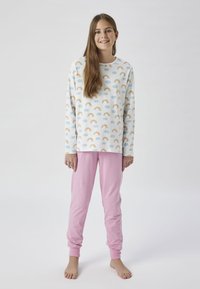 Ensemble de pyjama en coton comprenant un haut à manches longues avec un imprimé de arc-en-ciel et de nuage dans des couleurs pastel, associé à un pantalon ajusté rose uni.
