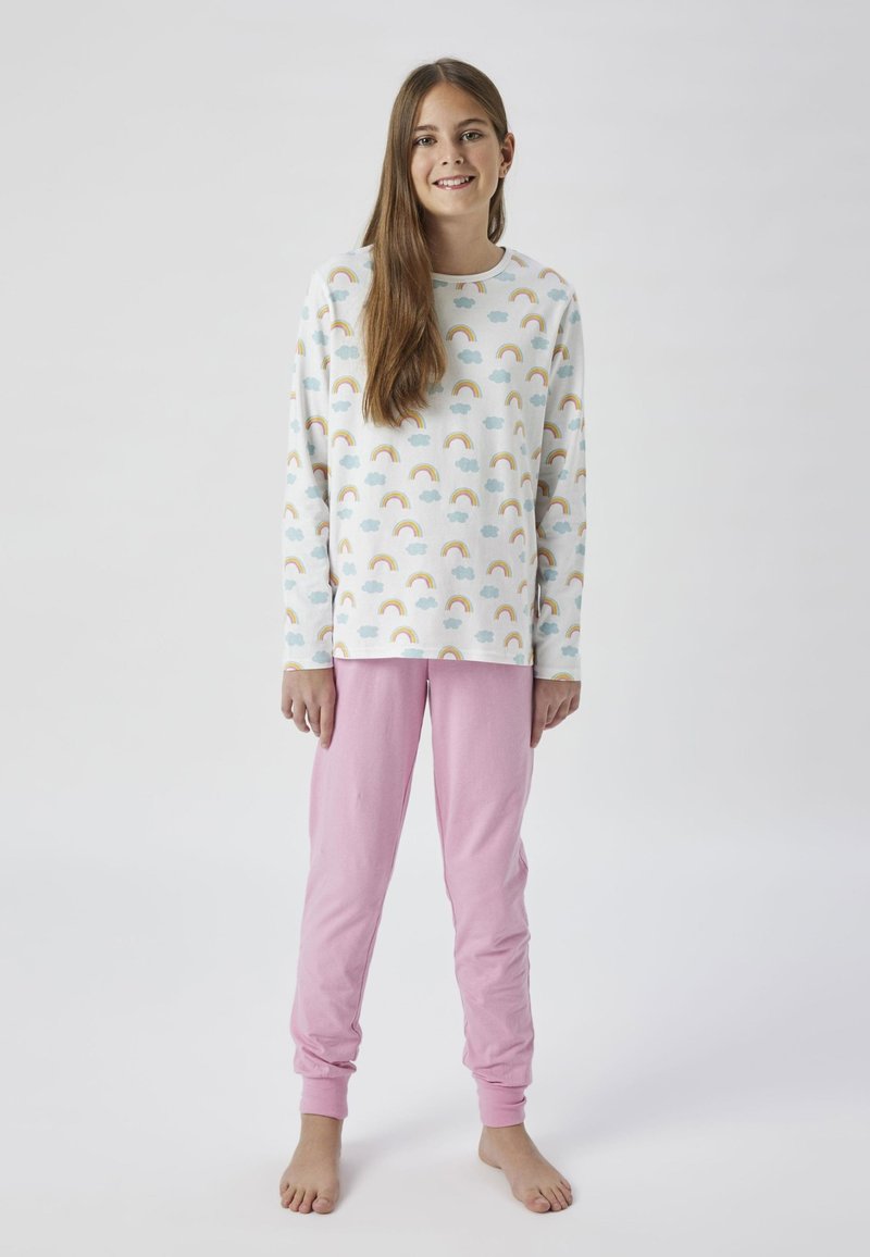 Ensemble de pyjama en coton comprenant un haut à manches longues avec un imprimé de arc-en-ciel et de nuage dans des couleurs pastel, associé à un pantalon ajusté rose uni.