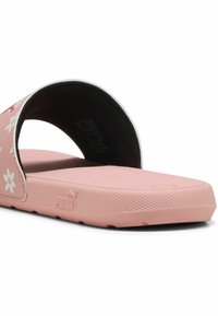 Rozā slīdējošās sandales ar ziedu rakstu, gumijas materiāls, strukturēta zole, atvērta purngala dizains un Puma logo sānos.