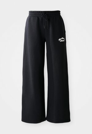 Sorte breddebenede sweatpants med snøre i livet. Har broderet tekst på venstre side, lavet af blødt bomuldsblandingsmateriale.