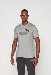 Grå bomull t-skjorte med korte ermer, med en fremtredende svart "PUMA" logo og et bilde av en sprangpuma på forsiden.