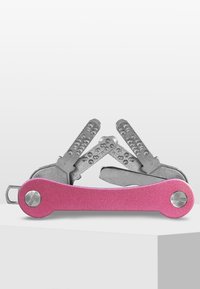 Multiverktyg med ett kropp av rosa anodiserad aluminium och verktyg i silverrostfritt stål, utrustad med strukturerade handtag och en kompakt vikdesign.