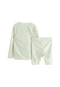 Ljusgrön randig långärmad tröja med raglanärmar i kombination med matchande shorts, tillverkade av mjukt, andningsbart tyg.