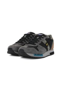 Sneaker in suede grigio e tessuto nero con lacci neri, dettagli in teal e tallone marrone. Presentano una suola testurizzata con un motivo a zigzag.