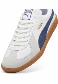 Fehér és tengerészkék sneaker, bőr és velúr felső résszel, kerek orral, fehér fűzőkkel és gumi talppal, márkajelzésekkel.