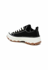 Sneakers neri in tela con lacci bianchi, suola spessa bianca e dettagli in gomma. Presentano cuciture a contrasto e una zona tallone testurizzata.