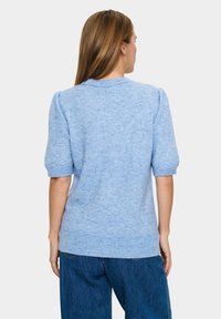 Helltürkiser Strickpullover mit kurzen Puffärmeln, geripptem Halsausschnitt und Saum, der einen leicht lockeren Schnitt und eine weiche Textur aufweist.