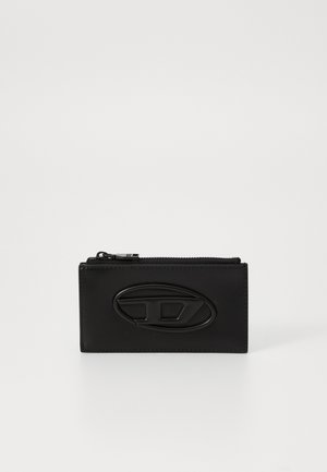 Portefeuille noir en cuir avec fermeture éclair, présentant un logo en relief bien visible à l'avant, une texture lisse et une forme rectangulaire aux lignes épurées.