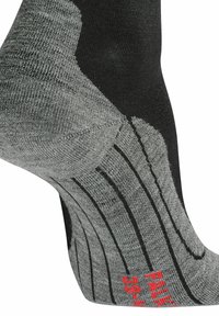Chaussette noire et grise avec un design en tricot texturé, talon renforcé et marque rouge. Des lignes de motifs spécifiques sont visibles sur le pied.
