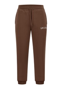 Brune joggerbukser lavet af blødt stof, med elastisk talje, manchetter og teksten "SMILODON" broderet i hvidt på siden.