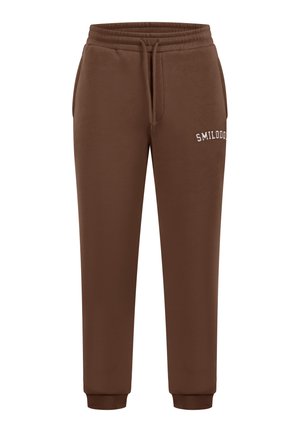 Pantaloni jogger marroni realizzati in tessuto morbido, con vita elasticizzata, polsini e la scritta "SMILODON" di ricamo bianco sul lato.