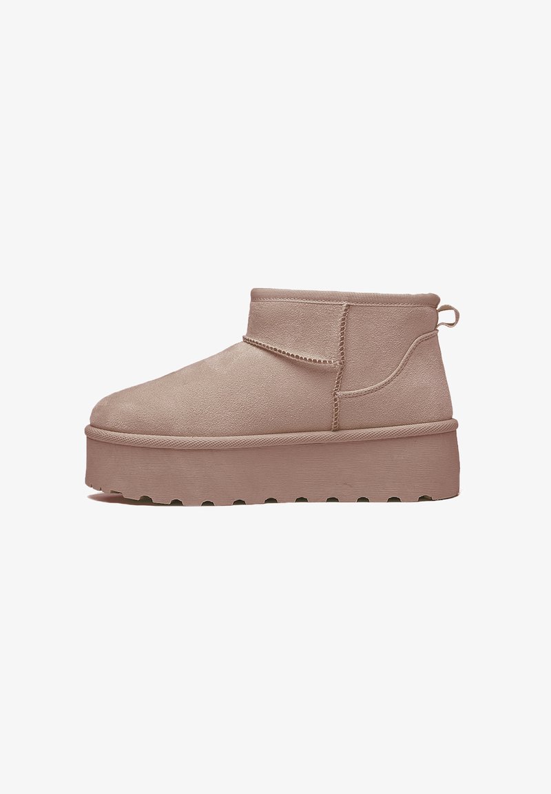Stivaletti beige alla caviglia con una finitura in morbido suede, dotati di una suola piatta, pannello laterale elasticizzato e una linguetta sul tallone.
