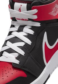 Hochschuhsneaker aus schwarzem synthetischem Material mit roten Akzenten, weißen Schnürsenkeln, einem silbernen Logo und Perforationen im Zehenbereich.