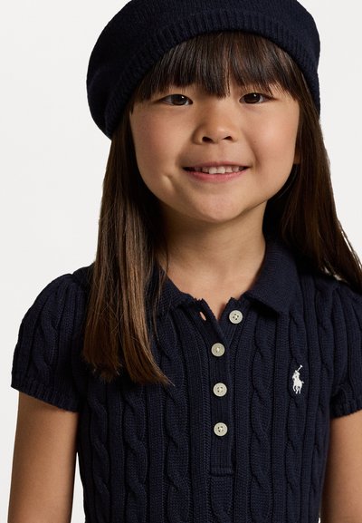 Polo de punto en color azul marino con mangas cortas, patrón de trenzado y tapeta de tres botones; presenta un pequeño logotipo blanco en el pecho.