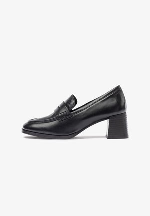Mocasines negros de cuero con tacón, con punta redonda, que presentan un diseño cosido y un tacón sólido con una superficie texturizada.