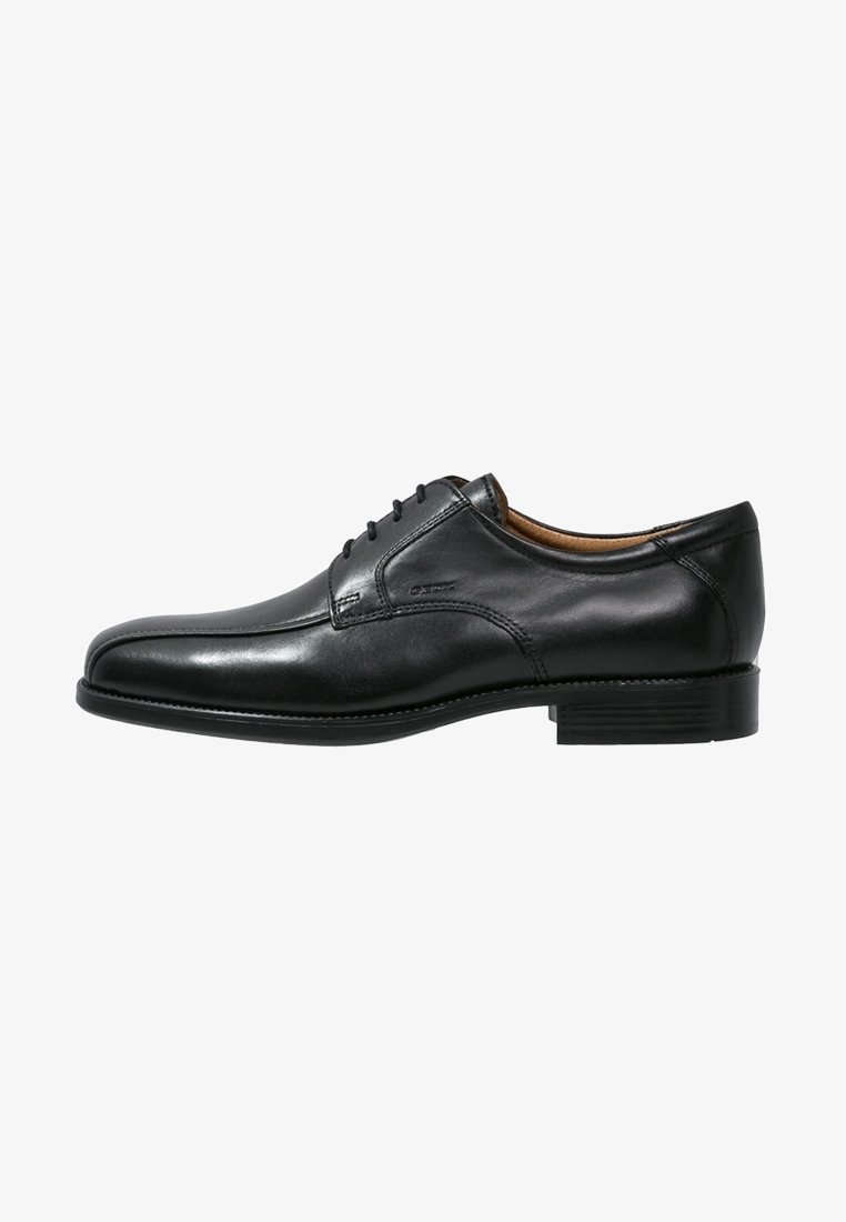 Chaussure habillée en cuir noir pour homme, à lacets sur le devant, talon bas et finition lisse et polie, présentée de profil sur fond blanc.