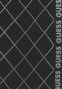 Czarna tkanina z wzorem diamentowym utworzonym przez srebrne cyrkonie; po boku kontrastuje srebrne logo "GUESS".